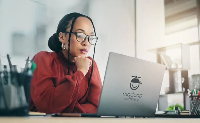 MadCap Software のロゴが付いたラップトップで作業する女性